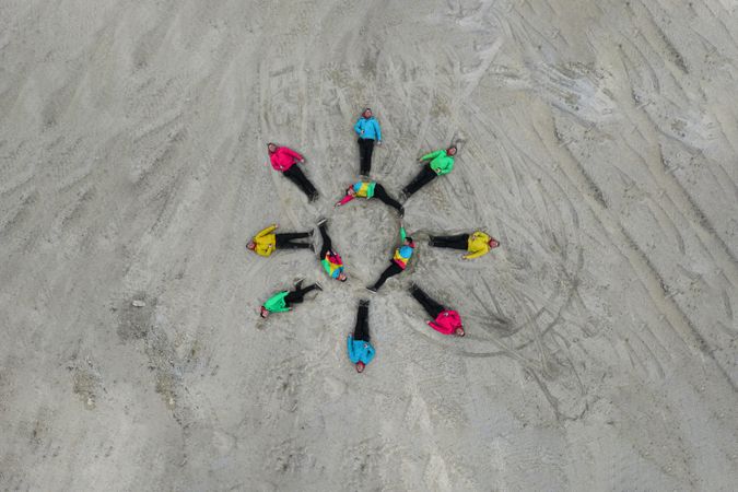 Vibrant top down aerial photo of a man laying down forming a representation of a sun, both for the spring and summertime.