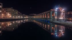 Illuminated buildings on city embankment in night