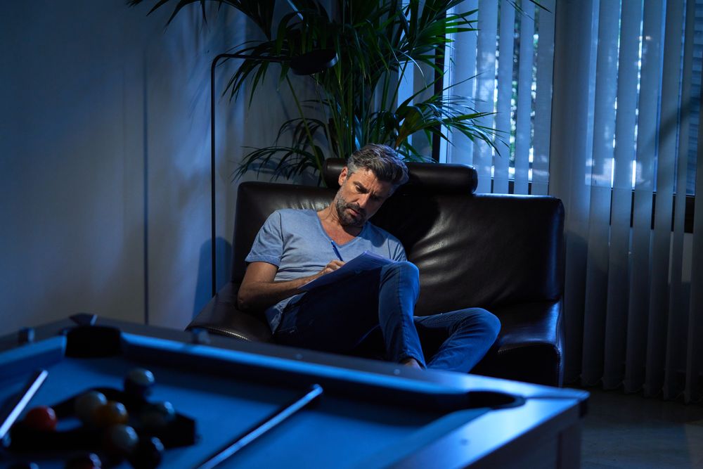 Concentrated office worker writing in papers at night