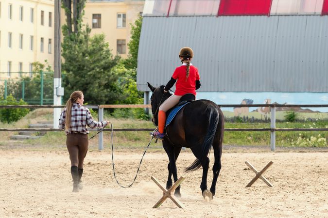 Instructor leads young rider during training session.