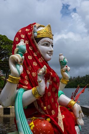 Red veiled Laksmi statue outside by lake