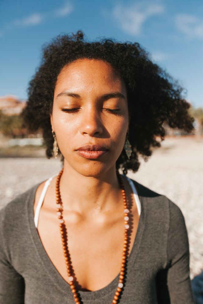 Sportive woman sitting on sandy beach in asana
