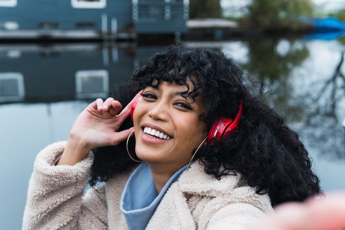 Smiling Black woman listening to music outside