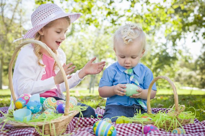 Cute Young Brother and Sister Enjoying Their Easter Eggs Outside