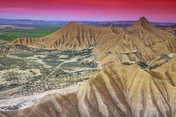 Stone desert hills near green field
