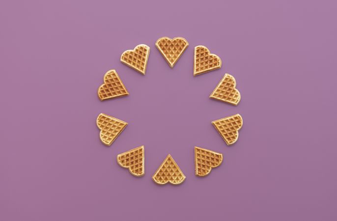 Heart shaped waffles top view on a purple background