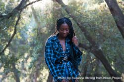 Portrait of Black woman with box braids standing in the woods bGRWB4