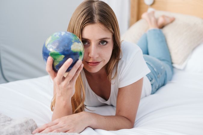 Young female lying with earth ball