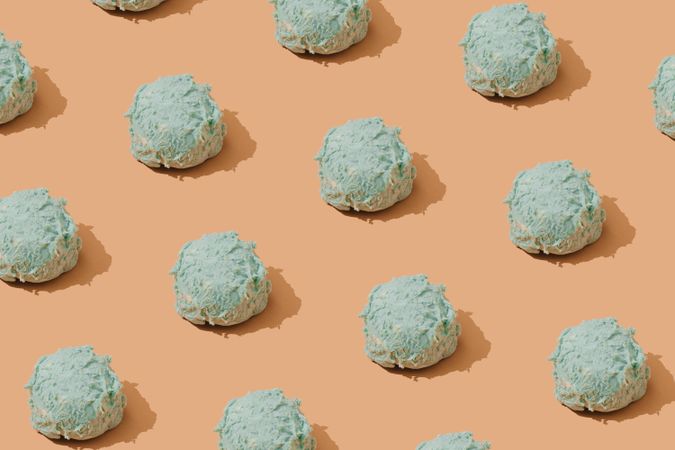 Pastel blue ice cream scoops in rows on brown background