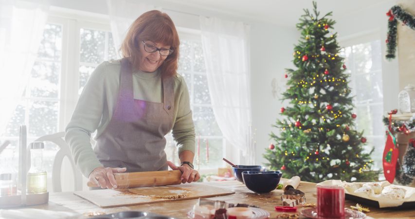 Portrait of Older Female Making Gingerbread Cookies for Christmas at Home.
