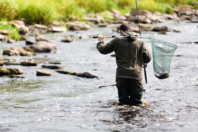 Fisherman Crossing River with Catch