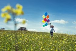 Kid having fun with balloons in nature