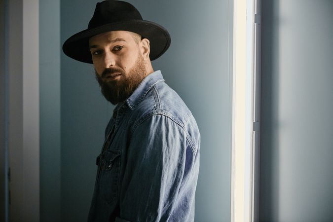 man in hat looking at camera in room