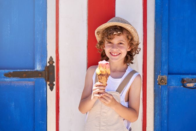 Cheerful boy with ice cream cone on street