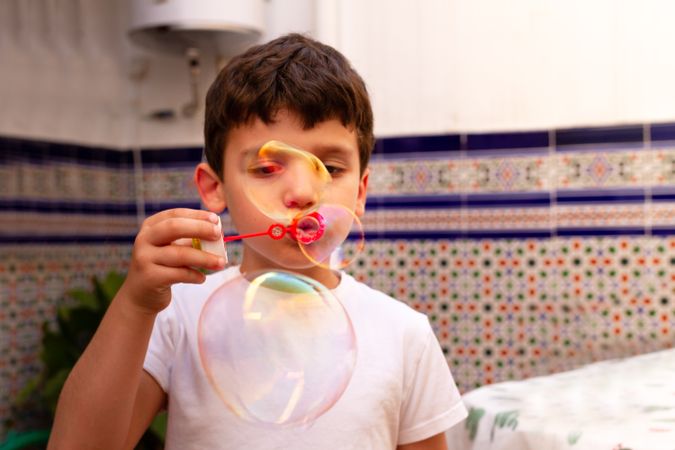Boy blowing bubbles on terrace