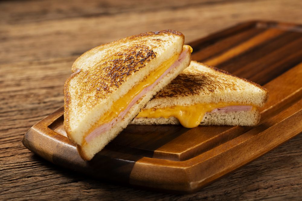 Grilled ham and cheese. Sandwich with cheese and ham on grill.