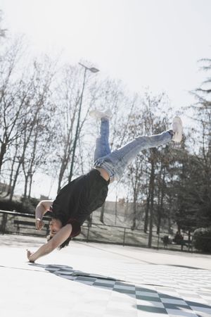 Man dancing break dance in park
