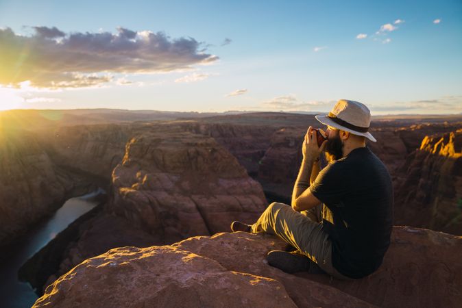 Man drinking near canyon