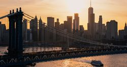 Helicopter Tour of New York City Architecture. Close Up Over the Manhattan Bridge. Panoramic View of Office Buildings and Skyscrapers in a Warm Evening Sunlight