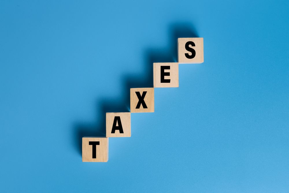 taxes word text on wooden blocks isolated on blue background