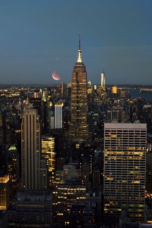 New York city skyline at night under crescent moon