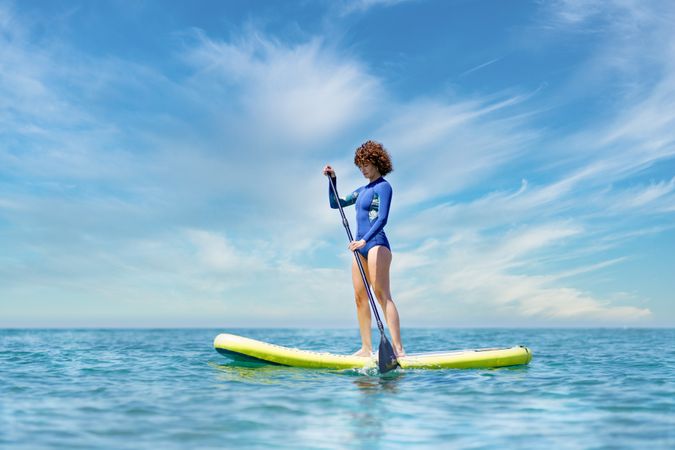 Woman paddle boarding on beautiful day