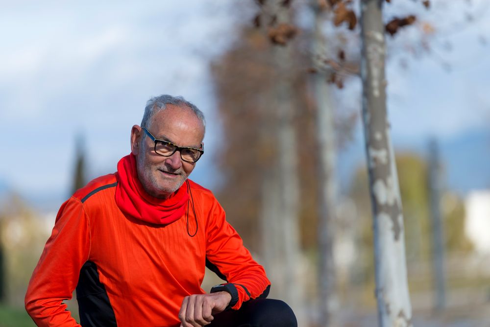 Portrait of fit grey haired male sitting outside