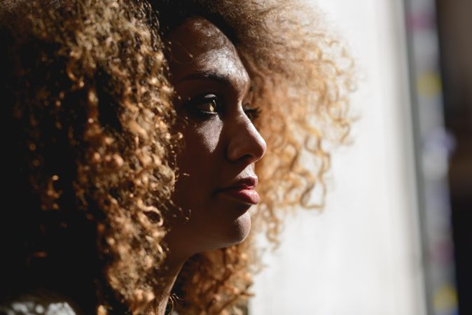 Woman with curly hair pictured in sun