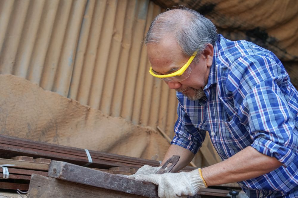 Asian carpenter working with wood in the shop