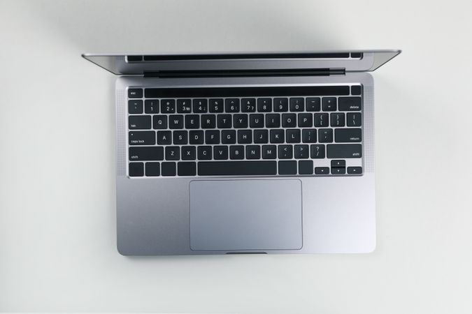 Close up of top view of opened silver laptop and keyboard on desk