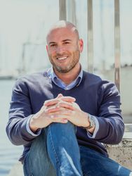 Vertical photo of a businessman sitting on the floor looking straight ahead