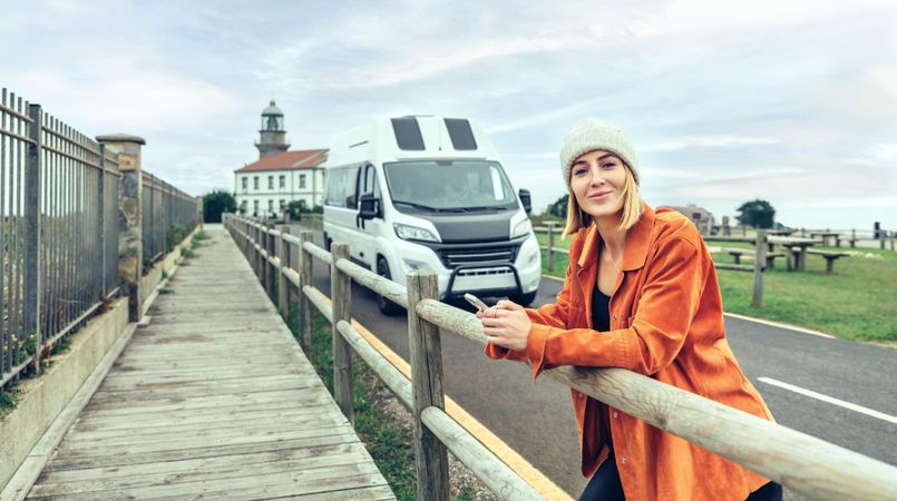 Female leaning on the rails, in front of parked van