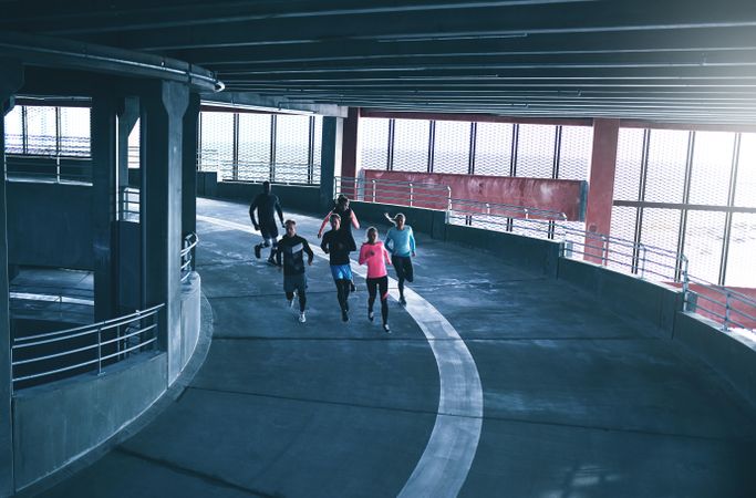 Rear view of people running in indoor track