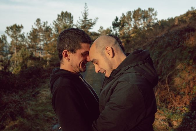 Smiling men hugging on countryside road