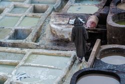 Person between big containers with colorant liquid