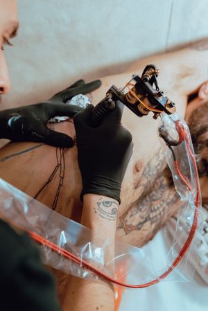 man drawing tattoo