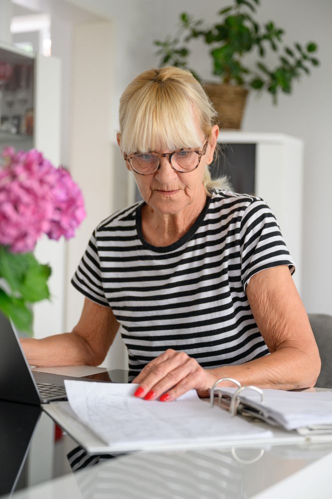 Woman checking documents while writing notes