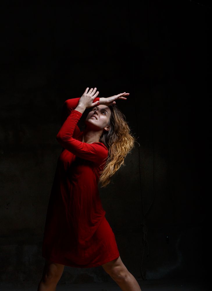 Young woman dancing in darkness