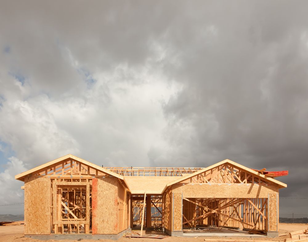 Wood Home Framing Abstract At Construction Site with Stormy Clouds Behind