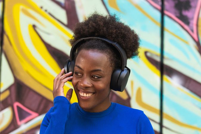 Positive woman enjoying music in city