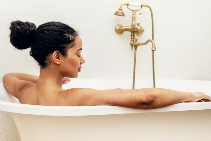 Back view of woman relaxing in a bath