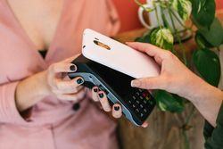 Anonymous woman paying for skin care treatment with smartphone on POS terminal