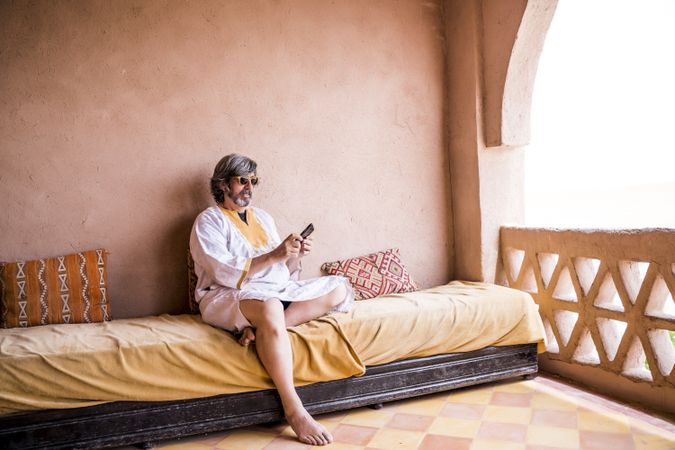 Man with phone on oriental stone terrace