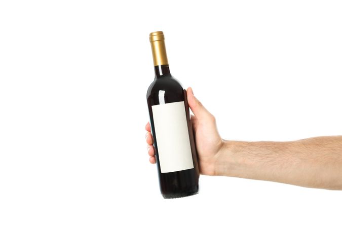 Male hand holding bottle of wine, isolated on light background