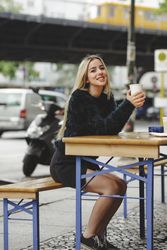 woman drinking coffee in street cafe