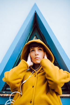Cheerful female near triangle window listening to the music
