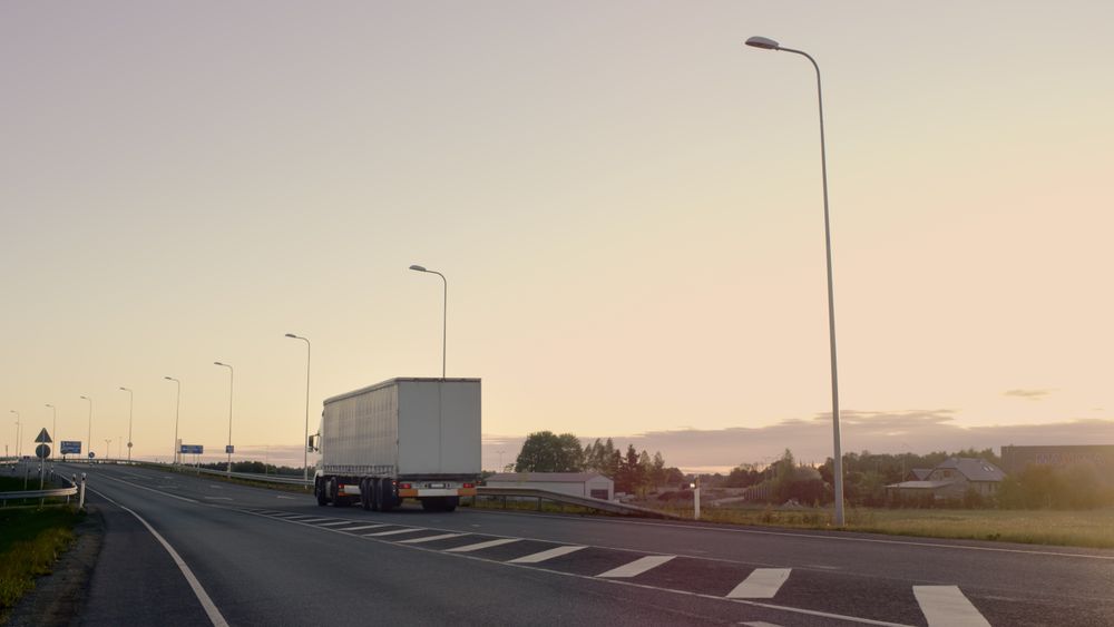 Semi-Truck with Cargo Trailer Drives on a Highway.