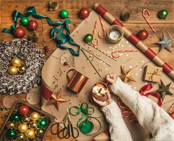 Festive scene with candy canes, star tree ornaments, ribbon, wrapping paper, woman holding mug