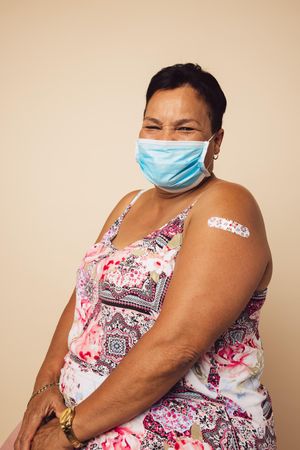 Mature woman with bandage on her arm after getting vaccine