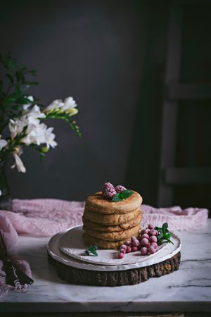 Pile of raspberry pancakes with honey on plate